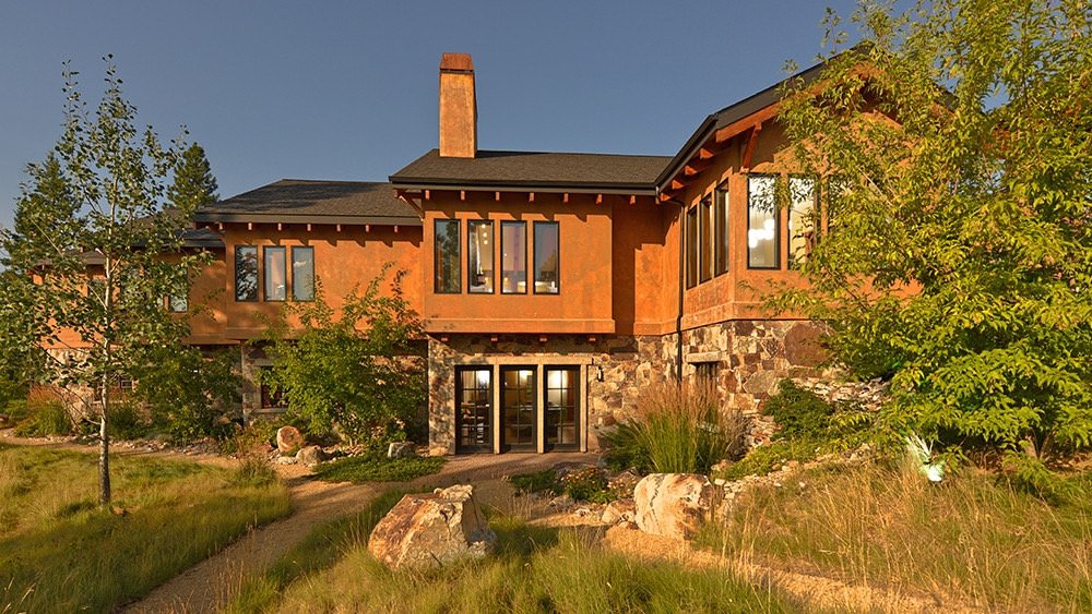 Rammed earth columns and hand-laid stone exterior with arched timber entryway, Carmel California