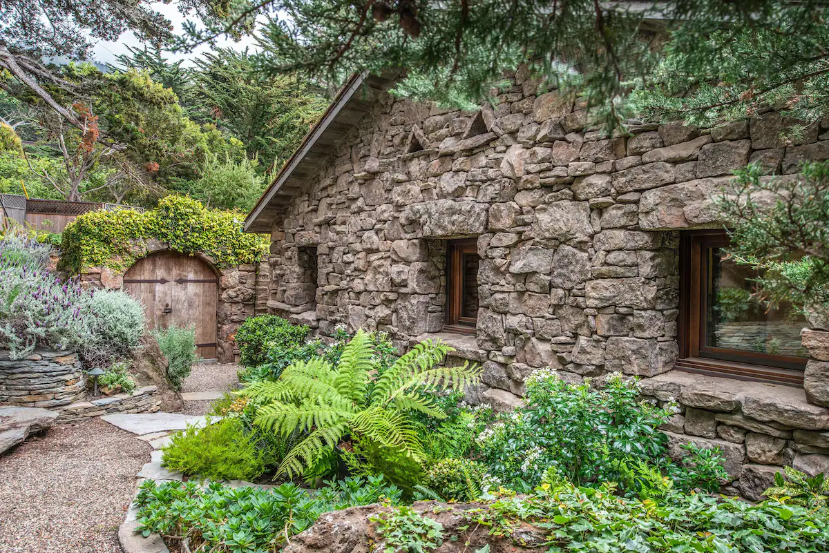 Stone and cypress coastal home exterior — eco construction by Alma Verde