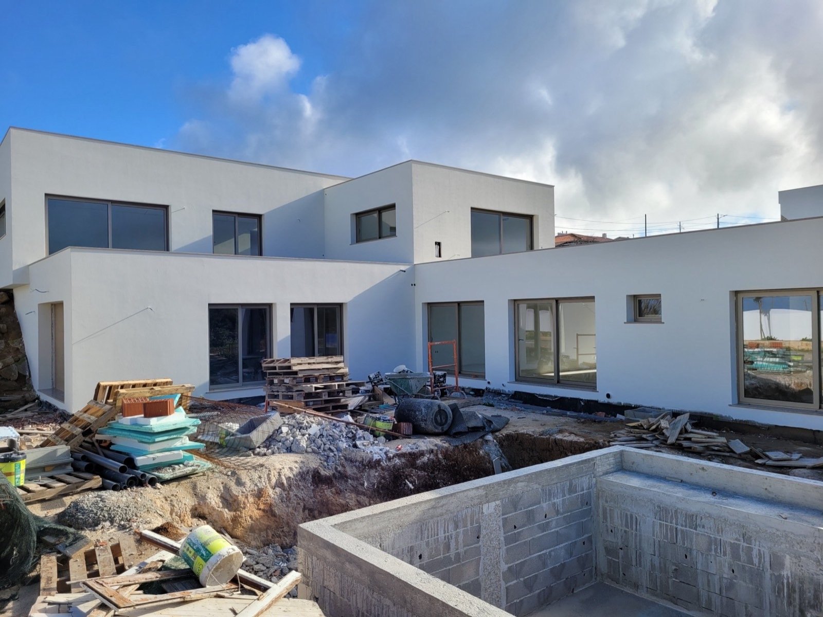 Contemporary white villa with stone terrace and open sky, Algarve Portugal — eco construction by Alma Verde