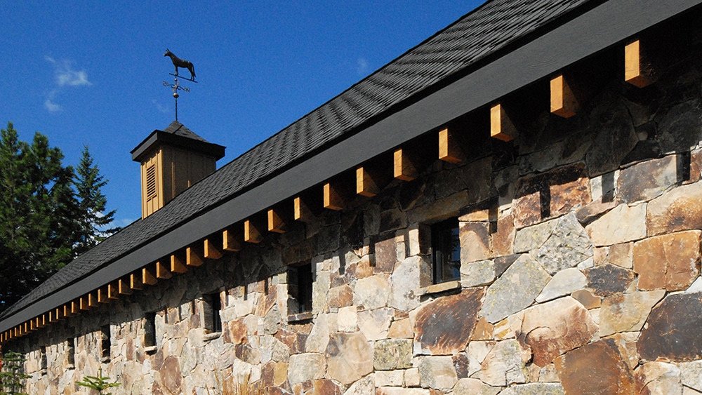 Precision dry stone masonry wall with timber eave detail — traditional Portuguese stonework